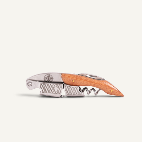 A folding pocket corkscrew with a light brown wooden handle and silver metal components, including a corkscrew bit and pocket clip, shown on a light off-white background.