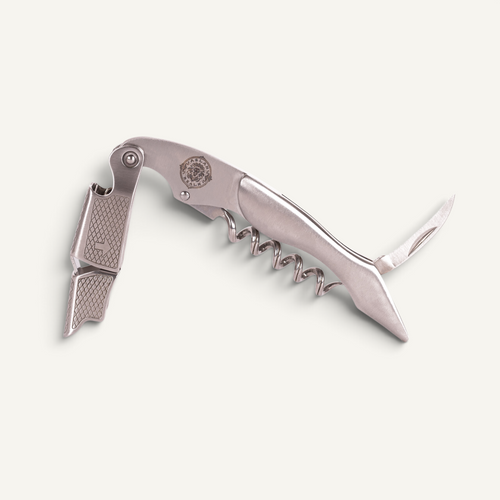 A stainless steel corkscrew with a bottle opener and knife blade extended, shown on a light off-white background.