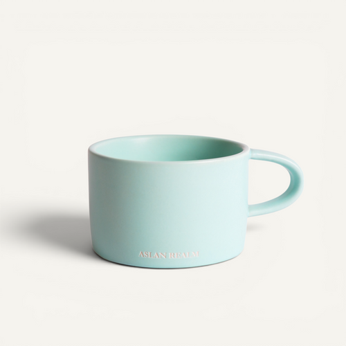 A ceramic espresso mug with a matte finish in a light blue color, featuring the brand name 'aslan realm' on the side.