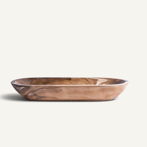 A shallow, oval-shaped wooden serving tray with a polished finish, showcasing natural wood grain patterns in warm brown and tan tones, set against a solid off-white background.
