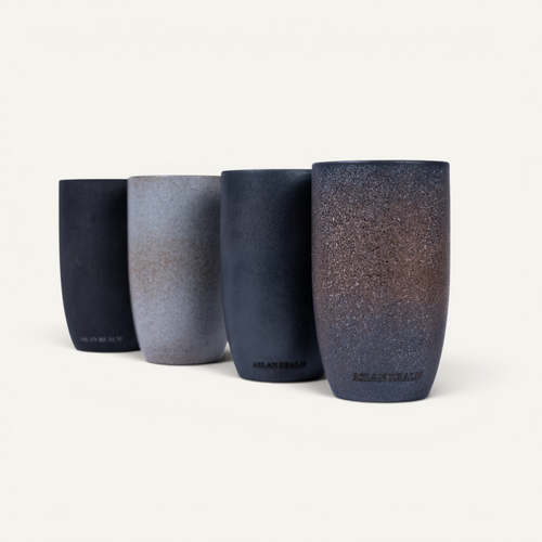 Four ceramic tumblers with gradient finishes on a white background