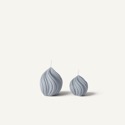 Two ribbed helix-shaped candles in a dusty blue-gray color, displayed side-by-side on a clean off-white background.