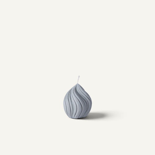 A small helix-shaped candle in a light gray-blue color with a ribbed texture and a single wick, centered against a solid off-white background.
