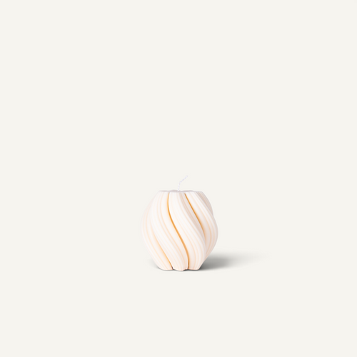 Three ribbed, rounded candles in pastel shades of lavender, terracotta, and cream, arranged side-by-side on a light beige background.