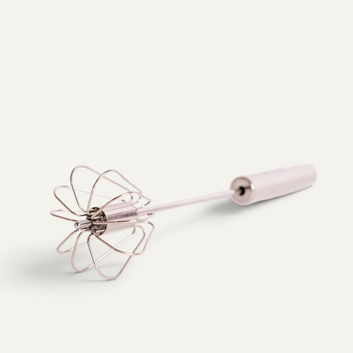 A stainless steel hand whisk shown on a clean off-white background.