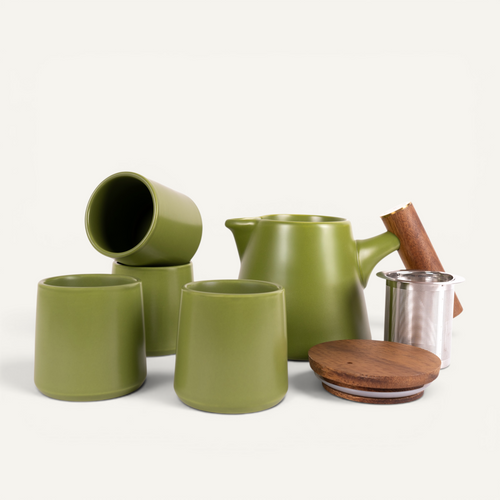 A set of green ceramic tea cups and a teapot with a solid walnut handle and a stainless steel infuser basket.