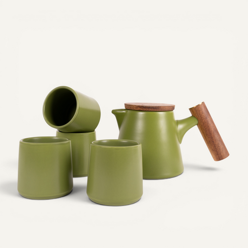A set of green ceramic tea cups and a teapot with a solid walnut handle and a stainless steel infuser basket.