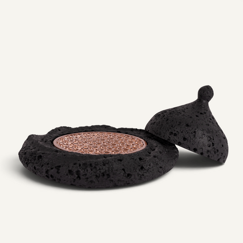 A Michelin style food presentation plate with volcanic texture and copper tray